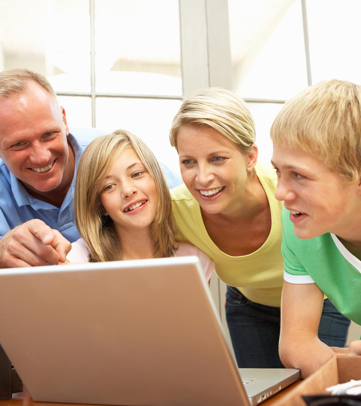 A boy and a girl watching laptop with their parents