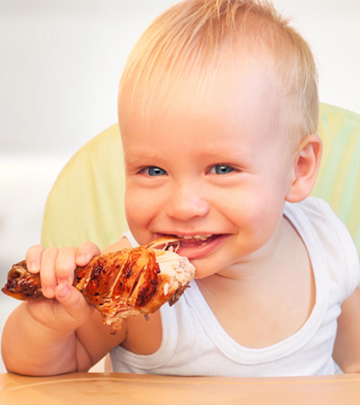 A baby eating chicken