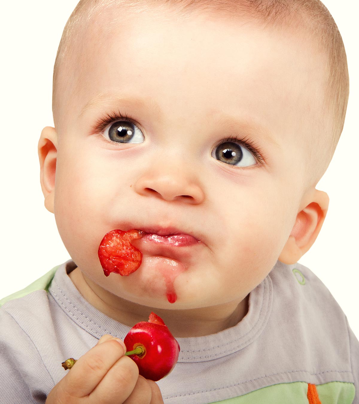A baby eating cherry