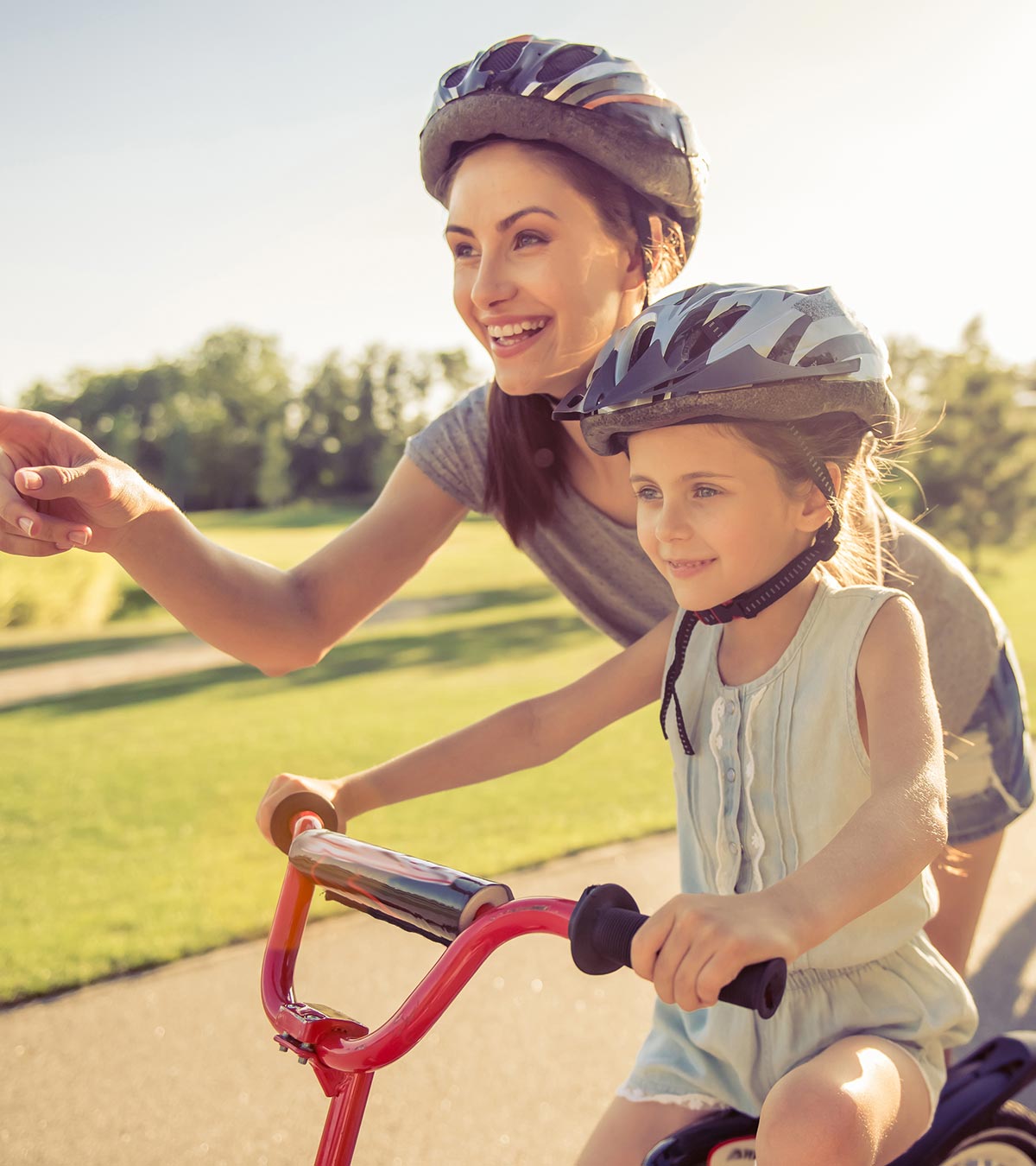 A girl riding a bicycle with her mother