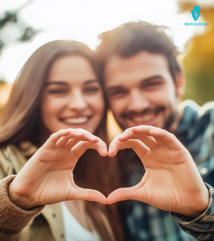 A couple showing the symbol of love with their hands