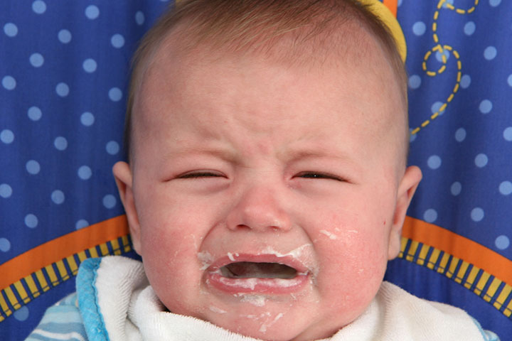 Baby cries when deals he spits up