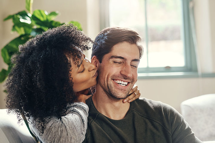 Man with his lovely sweetheart girl kiss at Lover's valentine day.  Valentine Couple. Couple kiss and hug. On background red balloons hearts.  Love concept. Happy smile girl. Lovers touch foreheads Photos