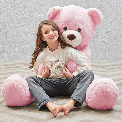 Cute teddy bear girl with a pink hear in her paws. Teddy bear on a